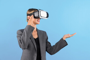 Wall Mural - Businesswoman with VR glasses standing and present idea with confident while standing at blue background. Professional project manager wearing suit while holding something. Technology. Contraption.