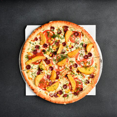 Wall Mural - Italian pizza with Bavarian sausages, fries and vegetables. Top view. Free space for text. On a gray stone background.