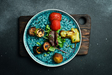 Wall Mural - Grilled vegetables on a blue round plate. On a black stone background.