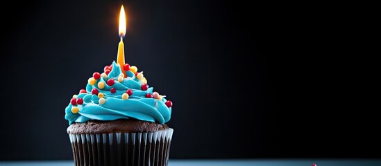 Poster - A festive cupcake with multi colored candles covered in blue glaze and bright decorations set against a white background providing ample copy space for an image