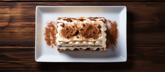 Poster - A top down perspective captures a delectable tiramisu dessert placed on a rustic wooden tabletop providing ample blank canvas for additional content within the frame