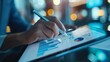 © Preecha - A close-up of a hand using a stylus on a digital tablet for business planning