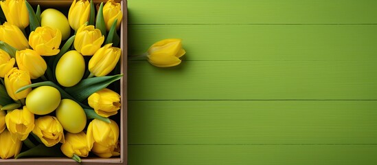 Aufkleber - A wooden box featuring a bright yellow Easter bunny toy plastic eggs and yellow tulips is a classic Easter decoration The photo is taken from a top down perspective with a green and yellow background