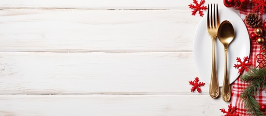 Poster - A festive Christmas holiday background featuring a red napkin and elegant cutlery arranged on a white wooden surface creating a copy space image