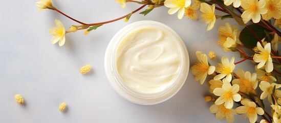 Poster - A healing face cream for troubled skin stored in an open jar with a textured appearance offers moisturizing care The image features copy space and showcases yellow flowers in a top view flat lay