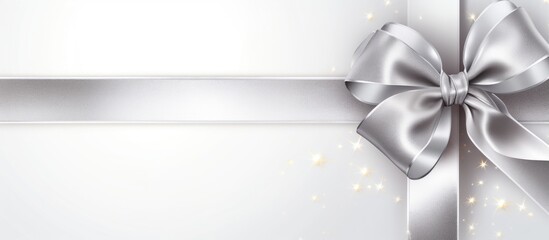 Wall Mural - A silver shiny satin ribbon bow with ribbon is positioned by the corner of a frame creating an isolated copy space image on a white background suitable for a holiday theme