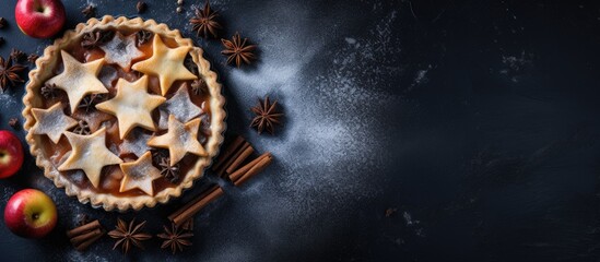 Poster - Top view of a dark blue background with a homemade apple pie dusted with sugar powder and garnished with fresh apples and spices Lots of copy space for an image