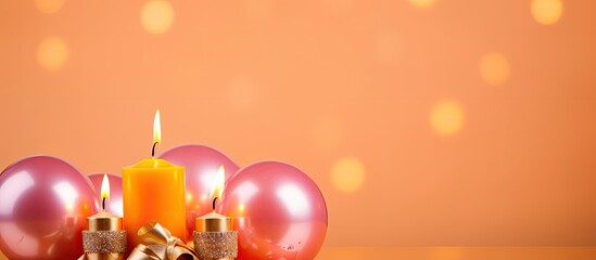 Fototapete - A festive arrangement of a fresh orange wrapped in foil adorned with a glowing candle and golden balls placed on a pink background Great inspiration for a birthday celebration Copy space image