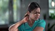 © Aamir - A young Indian woman with neck pain suffering from back in living room