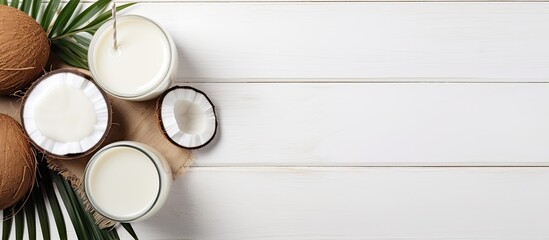 Poster - Flat lay copy space image of coconut products on a white wooden table background including a dairy free milk substitute drink Perfect for a healthy eating display