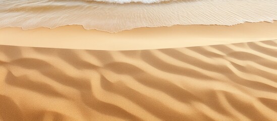 Aufkleber - Sea sand with a textured surface marked by bird tracks creates a natural background The waves of sand resembling dunes can be seen from above providing a copy space image