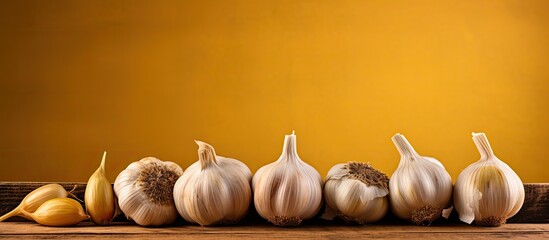 Aufkleber - A close up of garlic on a wooden board with garlic heads neatly arranged on a vintage yellow table There is ample copy space next to the spices for adding text