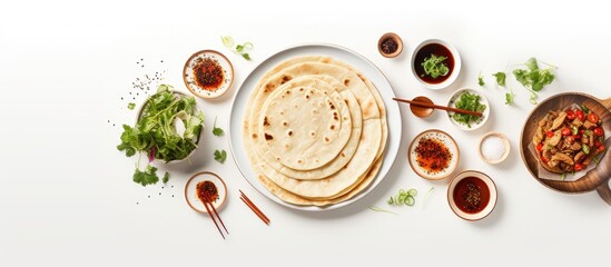 Wall Mural - From an aerial perspective there is a copy space image of traditional Chinese tortillas filled with bings placed neatly on a white plate against a simple white backdrop On the same plate there are al