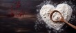 © HN Works - Top view of a dark table with a heart made of flour along with the text Cook and a rolling pin It serves as a baking background image with copy space
