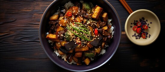 Poster - Top view of a Korean Chinese or Asian vegan meal featuring a bowl of glazed fried aubergine stir fry with a sweet soy sauce glaze Includes copy space for image composition