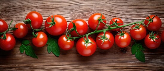 Poster - A top view image of fresh red cherry tomatoes on a branch placed on a kitchen table The image conveys the concept of growing vegetables and healthy eating Copy space is available