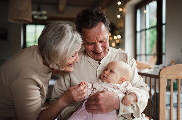 Grandparents holding baby girl, calming her down, soothing her. Strong bond between grandparents and grandchild.