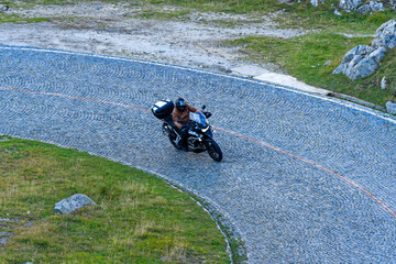 Wall Mural - Scenic view of mountain pass road named Tremola with motorcyclist way up at Swiss mountain pass Gotthard on a sunny late summer day. Photo taken September 10th, 2023, Gotthard, Switzerland.