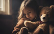 © julien.habis - Child hugging a teddy bear, sitting alone in a dark room, concept of childhood trauma and loneliness