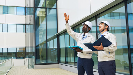Poster - Group of multinational engineers inspecting a building