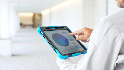 Poster - Engineer checking a building while looking at a tablet