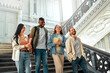 © Valerii Apetroaiei - College students bonding in a historic building stairwell on campus, creating a lively atmosphere