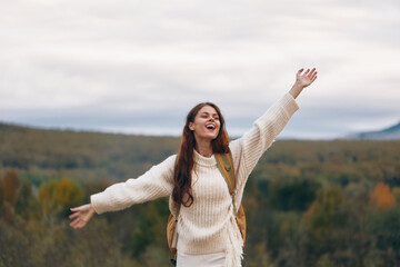 Wall Mural - Mountain Adventure: Smiling Woman Embracing Nature's Freedom on Cliff