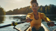 © chekart - A black African focused athletic woman in a yellow sports jersey is rowing on a lake. She is actively working with paddles. A sports concept