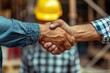 © Minerva Studio - Close up of a professional construction business handshake between two workers wearing hard hats on a jobsite, symbolizing agreement, teamwork, and collaboration in the building industry