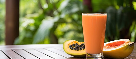 Poster - Tropical exotic papaya fruit and glass with smoothie shake juice drink outdoors with palm leaves. Creative banner. Copyspace image