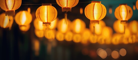 Aufkleber - A row of yellow lanterns at night against a blurred background The subject is out of focus. Creative banner. Copyspace image