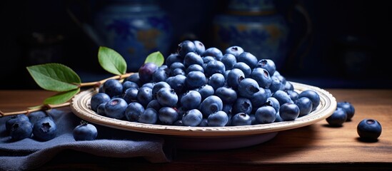 Poster - A bunch of ripe vaccinium corymbosum with black skin and a sweet taste are on a small plate in the kitchen. Creative banner. Copyspace image