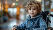 © Larisa AI - A young boy sitting in a wheelchair wearing a denim jacket smiles warmly, representing hope, youth, and positivity