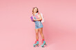 © ViDi Studio - Young smiling girl student wear casual clothes backpack bag rollers rollerblading hold books look aside isolated on plain pink background. Summer sport leisure, high school university college concept.