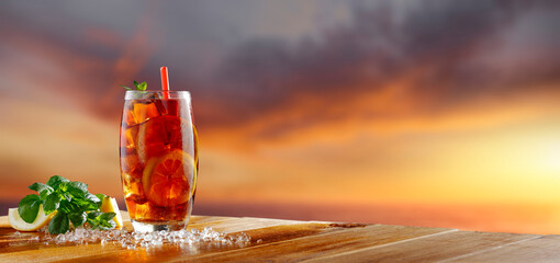 Sticker - Desk of free space and glass of ice tea with cold ice cubes. 