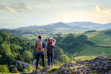travellers couple hiking on easy trail in nature with backpacks. young tourist resting, enjoying bre