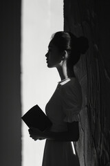 Poster - Minimalist silhouette of a woman holding a book on a white and grey backdrop,