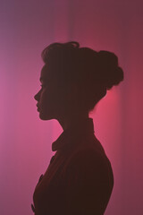 Poster - elegant silhouette of a female figure standing tall on a soft pastel background,