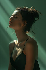 Poster - Elegant silhouette of a woman in a meditative pose on a soft green gradient background,