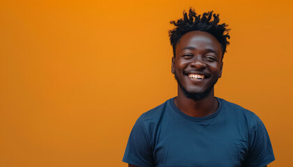 Wall Mural - A smiling man in a blue shirt is standing in front of a yellow wall