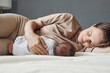 © sementsova321 - Nursing mother. Mother breastfeeding home. Breast milk benefits. Caucasian beautiful mother breastfeeding her baby while lying on bed