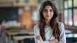© James - Confident young female Pakistani student standing in classroom, poised, confident posture, determined expression, academic setting, classroom environment.