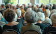 © Curioso.Photography - A large gathering of elderly people seated in a hall, viewed from behind, indicating a community event or meeting.