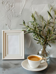 Aufkleber - A bright composition featuring a blank frame, a white cup of coffee, and a vase with olive branches on a gray surface
