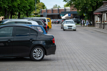 Wall Mural - Black car parked on city street. Background with selective focus and copy space.