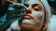 © olegganko - Woman Receiving Facial Treatment With Clay Mask