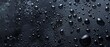 © STOCKYE STUDIO - Water droplets shimmer on an all-black, matte background, creating a striking visual contrast