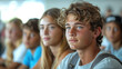 © Serega - A diverse group of students attentively listening to a teacher in a modern classroom, with digital devices in use