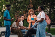 © Zamrznuti tonovi - Interracial college boys and girls chatting at campus during break.