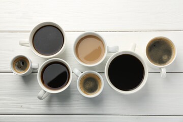 Poster - Different coffee drinks in cups on white wooden table, flat lay